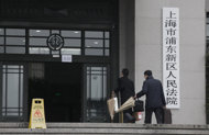 Lawyers for Shenzhen Proview Technology walk in a court house in Shanghai, China, Wednesday Feb. 22, 2012. The lawyer for a Chinese company suing Apple Inc. in China over its use of the iPad trademark indicated Tuesday that his client would be willing to discuss a settlement.